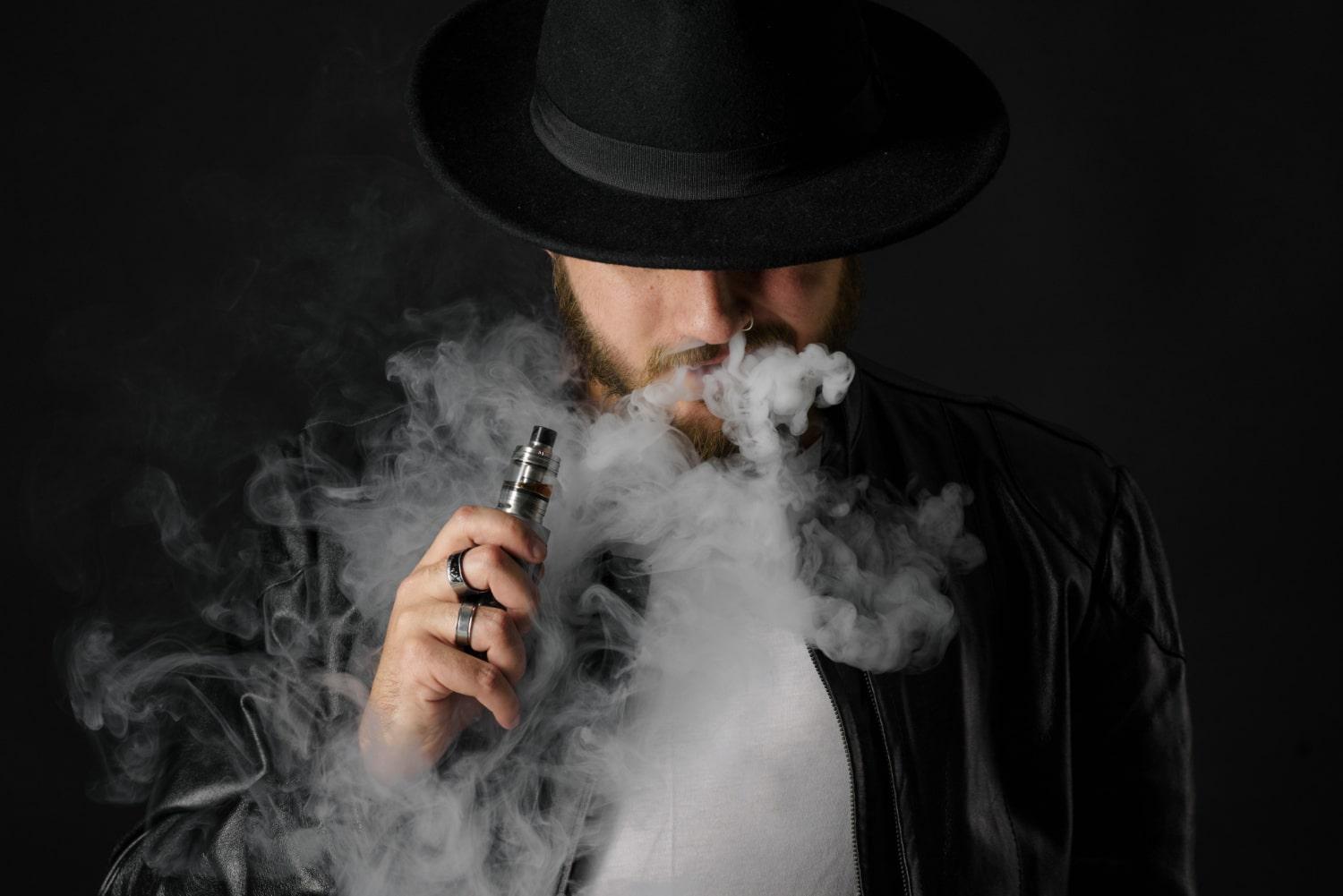 man with vaping mod exhaling steam black studio bearded guy smoking e cigarette quit tobacco vapor alternative nicotine free smoking concept min